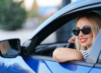 napszemüveges nő kék autóban autós horoszkóp