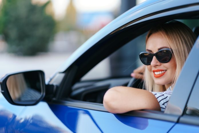 napszemüveges nő kék autóban autós horoszkóp
