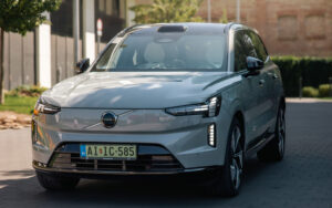 Volvo EX90 Ultra Twin Motor Performance szemből, Ködszürke színben, városi környezetben.