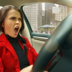 Driving around city. Young attractive woman driving a car