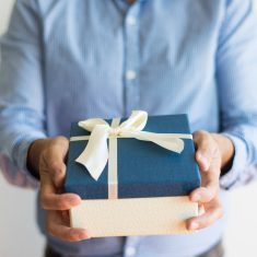 Close-up of unrecognizable man giving gift box to camera