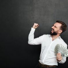 Portrait of successful guy in white shirt rejoicing like winner