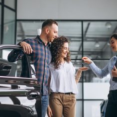 Young couple choosing a car in a car show room