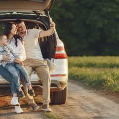 Family in a summer forest by the open trunk