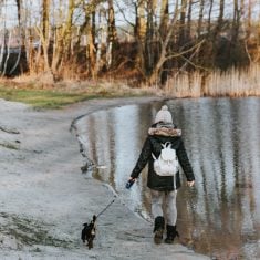 kaboompics_Woman-walking-the-dog-by-a-lake