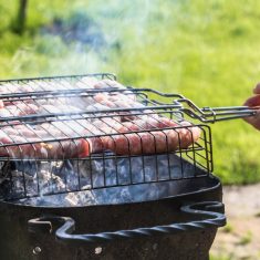 Friends making barbecue and having lunch in the nature.