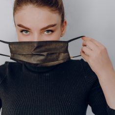 young attractive girl on a light background wears a medical mask. use of personal protection. anti-epidemic and anti-pollution protection of the person.