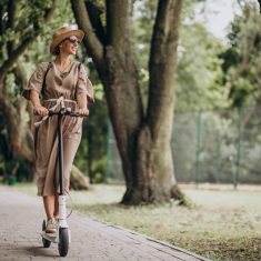 Young woman riding scooter in park