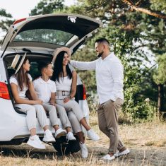 Parents with their children on car in the field