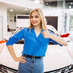 Woman showing emotions standing in front of a car