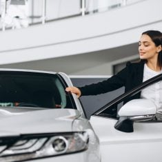 Woman choosing a car in a car showroom