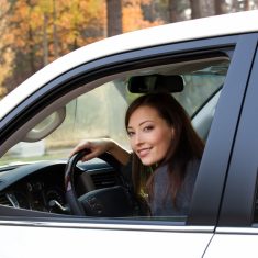 smiling woman sits in the new car
