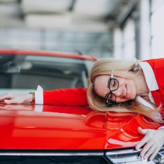 Elderly woman hugging an auto mobile at a car showroom