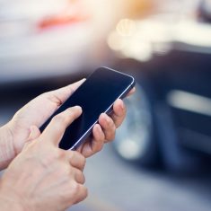 woman using smartphone at roadside after traffic accident, soft