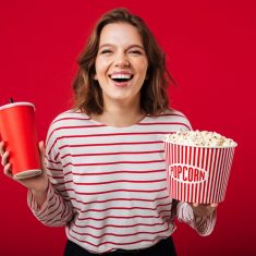 Portrait of a laughing woman holding popcorn