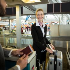 Airline check-in attendant sticking tag to the luggage of commuter at airport