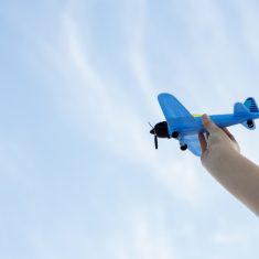 Hand playing with toy plane