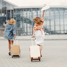 Two beautiful girls standing by the airport
